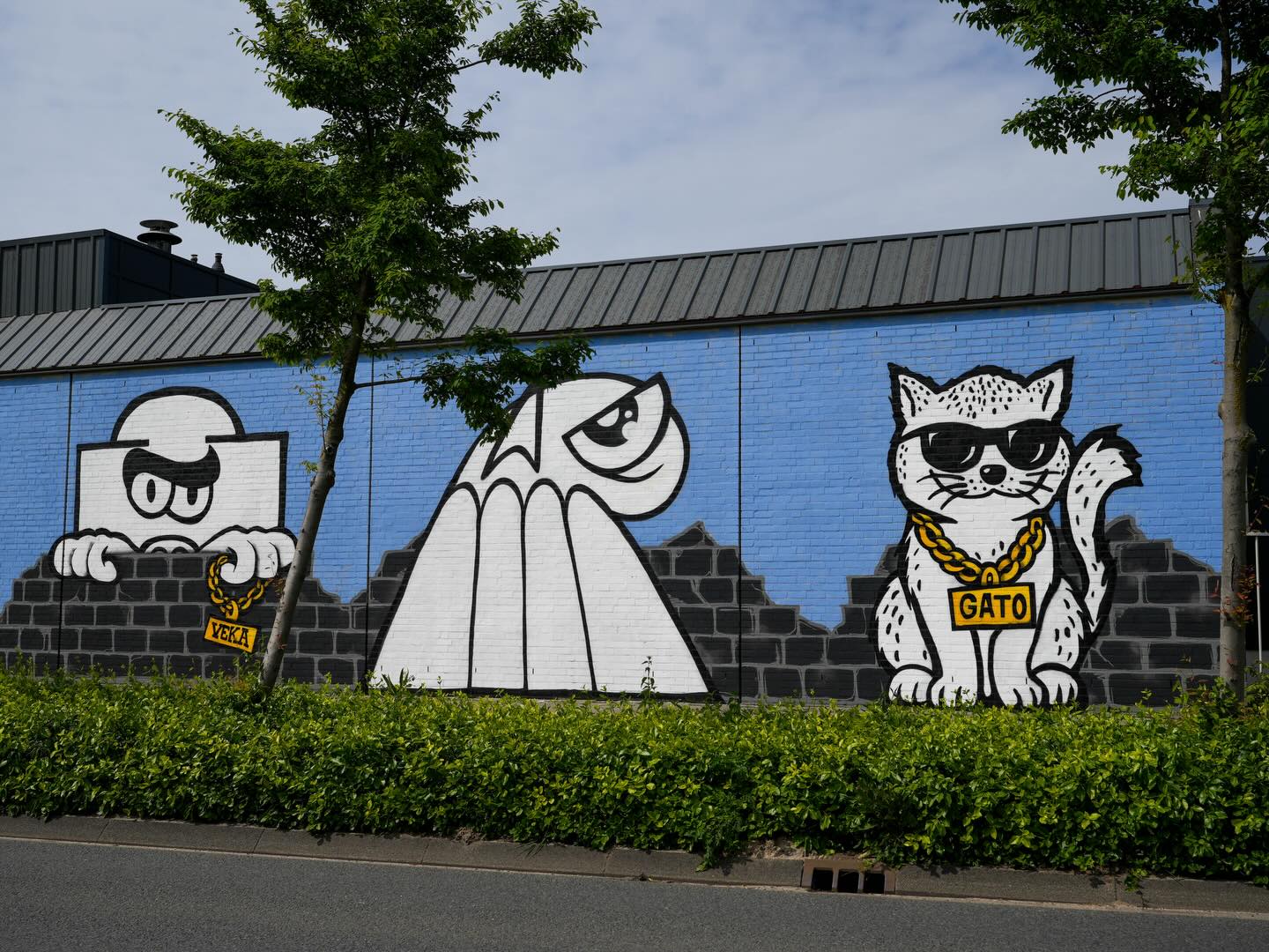 A large collaborative street-art work featuring Gato and other figures