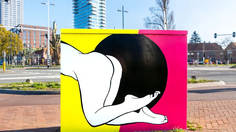 Felgekleurd verkeerskastje aan de PSV-laan in Eindhoven met een minimalistische zwart-witte figuur van Hanneke Wetzer.