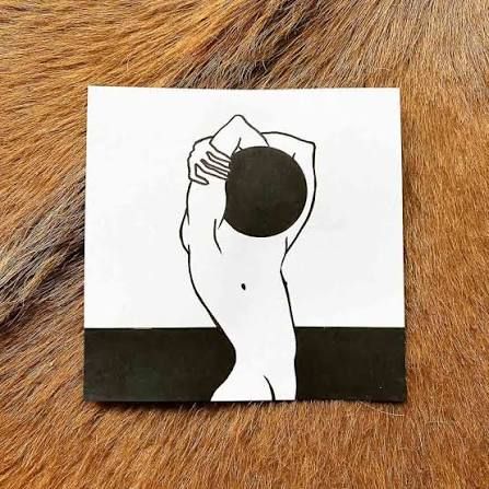 Hand houdt een zwart houten lijstje vast met een minimalistische zwart-witte Being-tekening van Hanneke Wetzer.